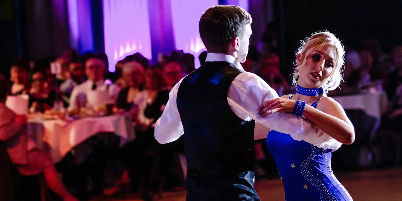 Couple dancing infront of a huge crowd.